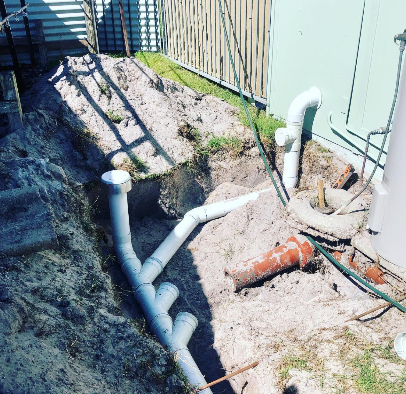A Crane is Lifting a Concrete Block Into the Ground in Front of a House — Shawline Plumbing and Drainage In Iluka, NSW
