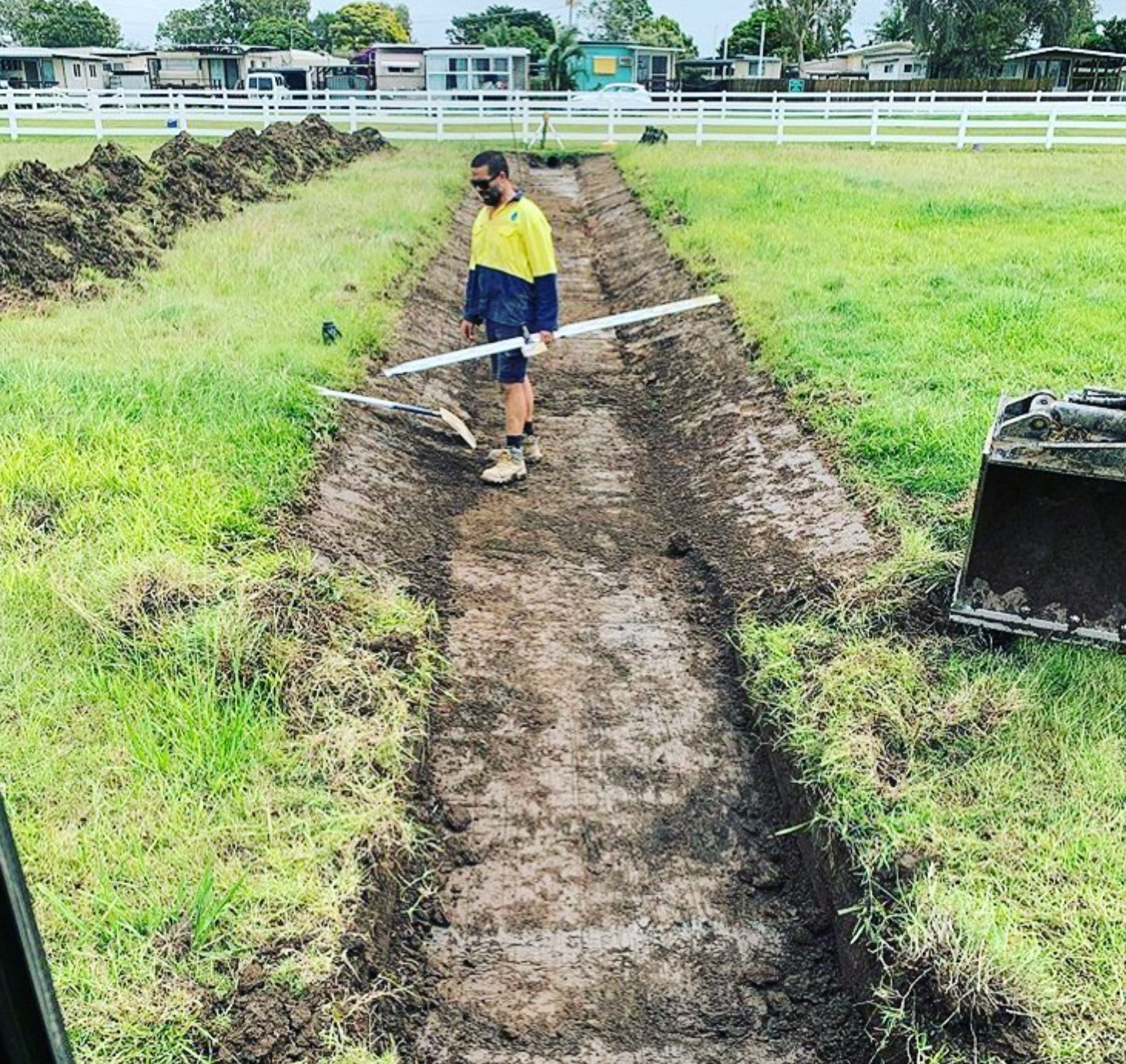 A Bulldozer is Digging a Hole in a Field — Shawline Plumbing and Drainage In Maclean, NSW