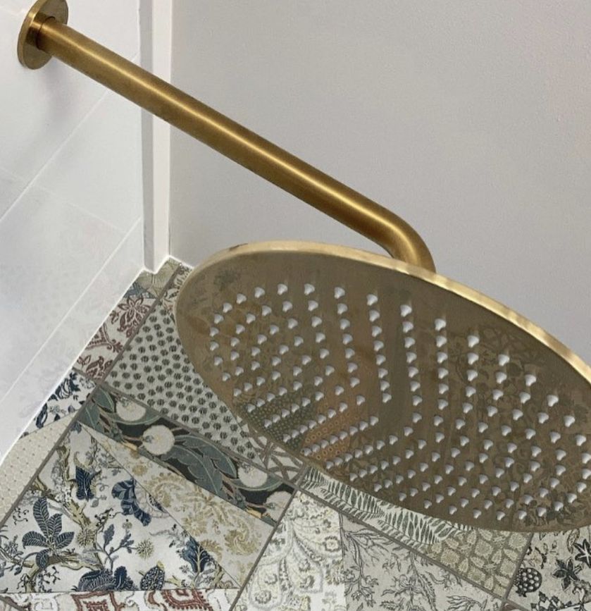 A Shower Head With Holes in It is Sitting on a Tiled Floor — Shawline Plumbing and Drainage In Iluka, NSW