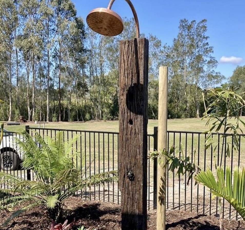 A Wooden Post With a Shower Head Attached to It — Shawline Plumbing and Drainage In Grafton, NSW