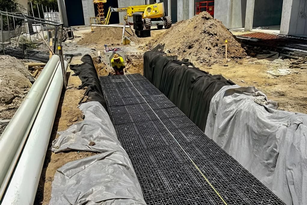 A Construction Site With a Large Pile of Dirt and Pipes — Shawline Plumbing and Drainage In Iluka, NSW