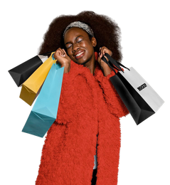 Woman holding shopping bags, smiling and wearing a red coat.