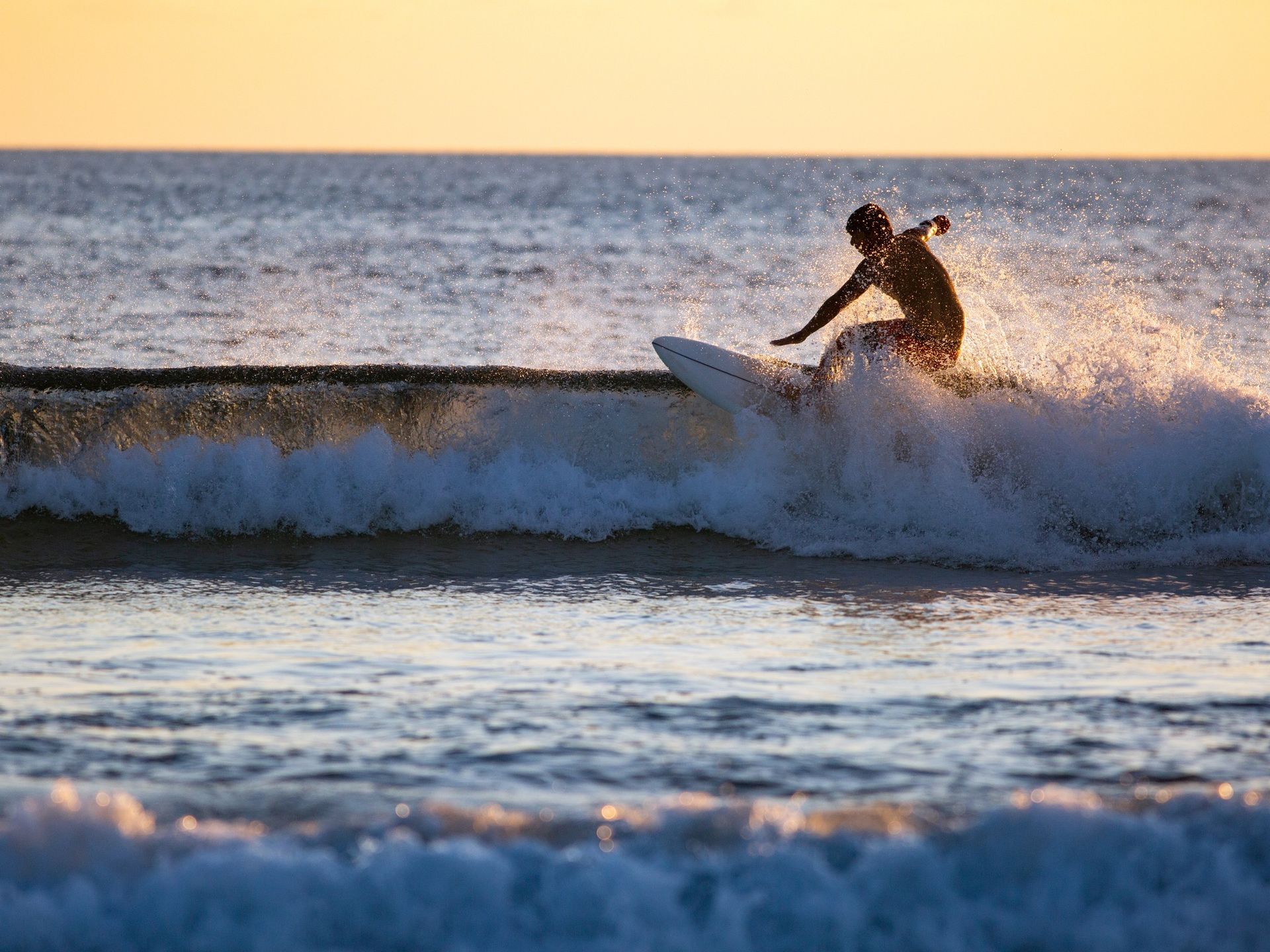 A person is riding a wave on a surfboard in the ocean.