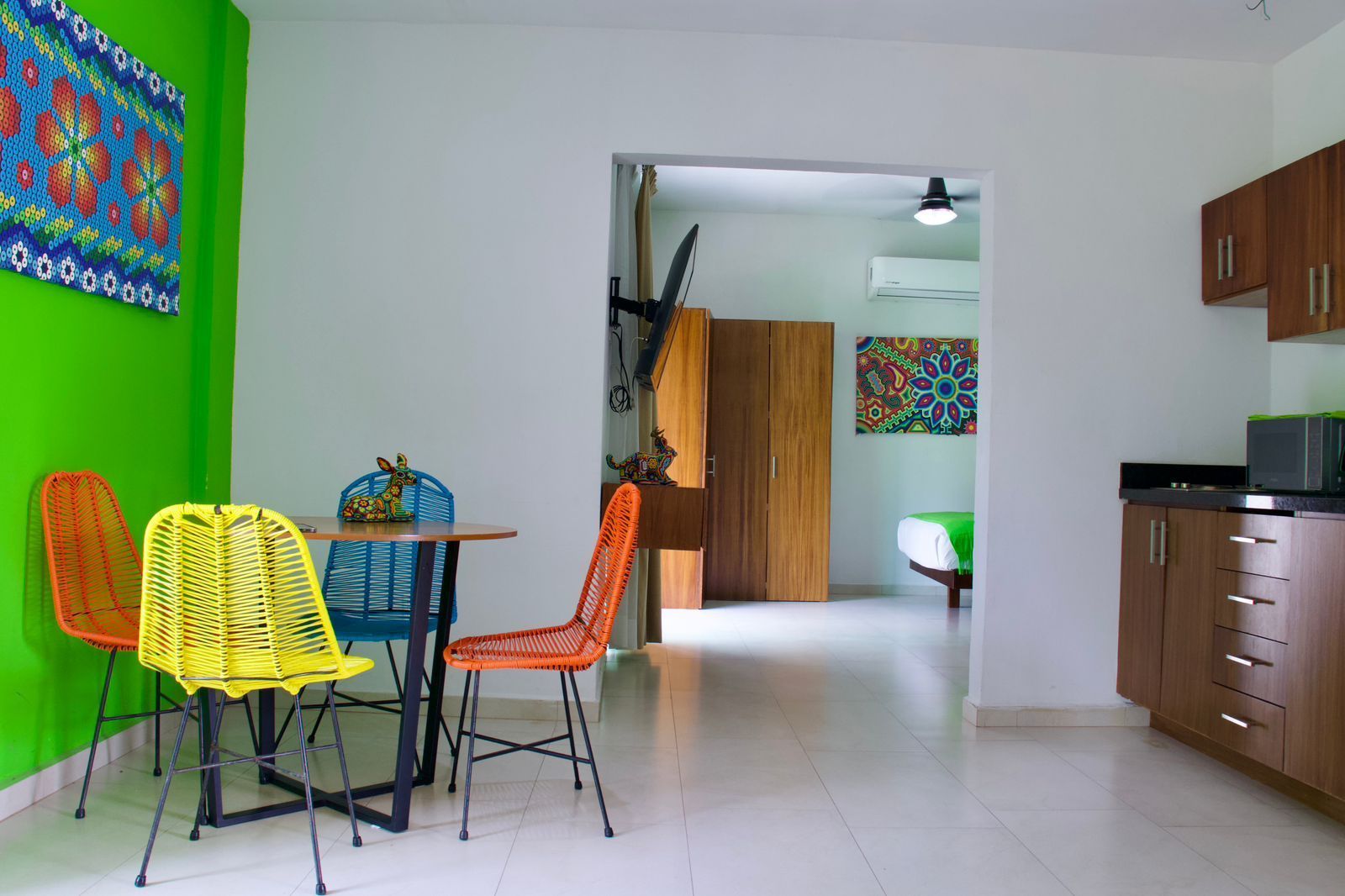 A living room with a table and chairs and a kitchen.