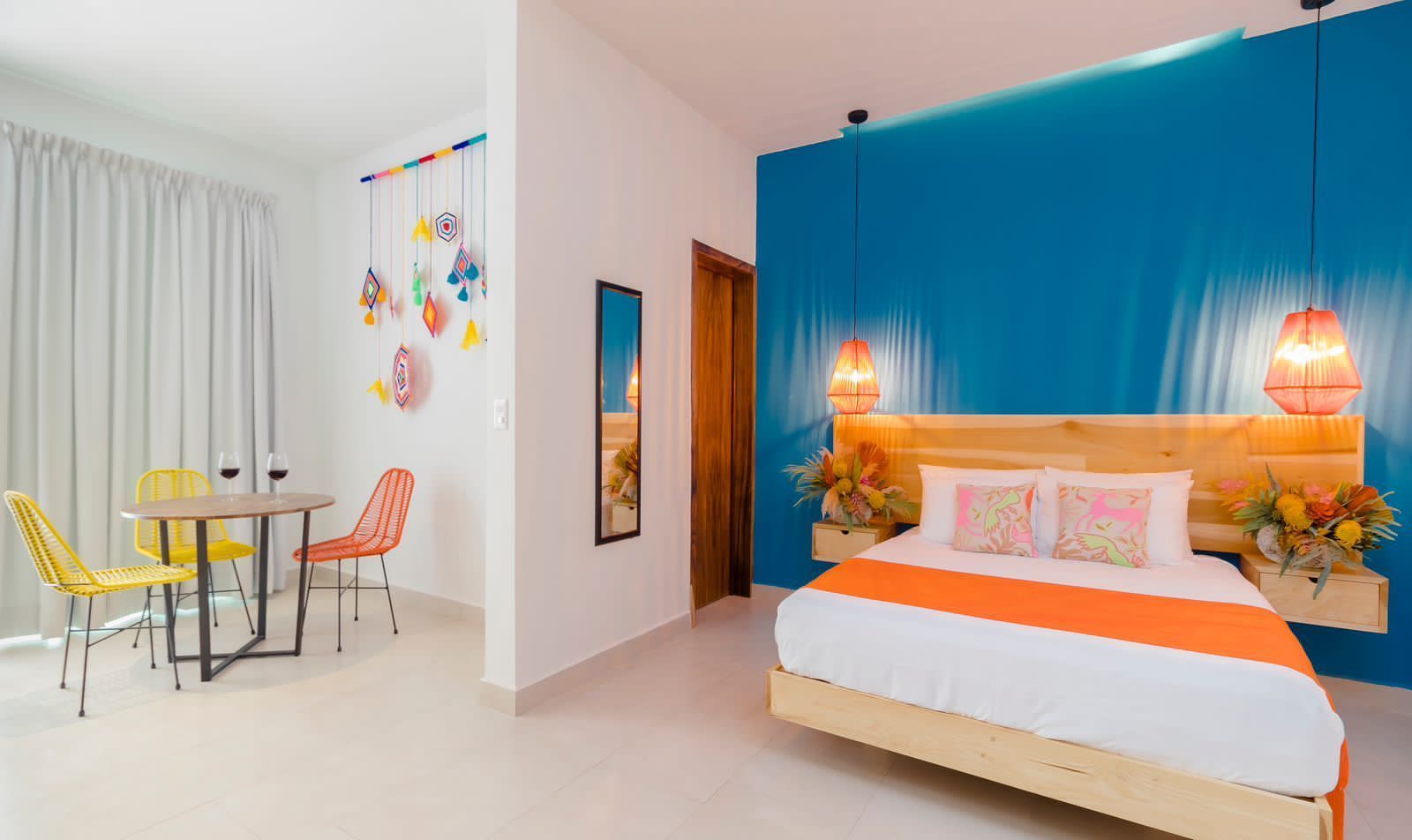 A hotel room with a bed , table and chairs.