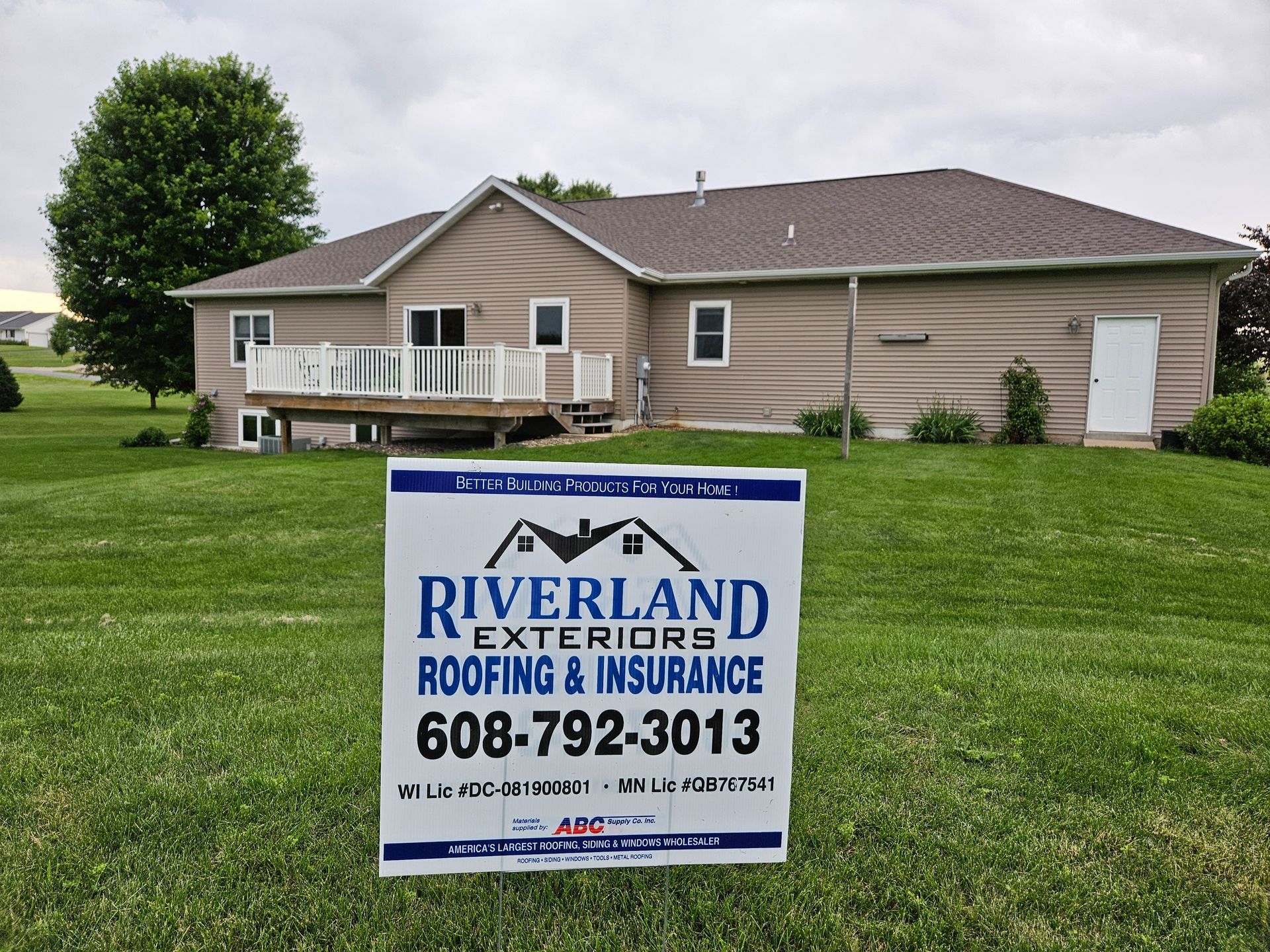 Sign for Riverland Exteriors in front of a house, 608-792-3013.