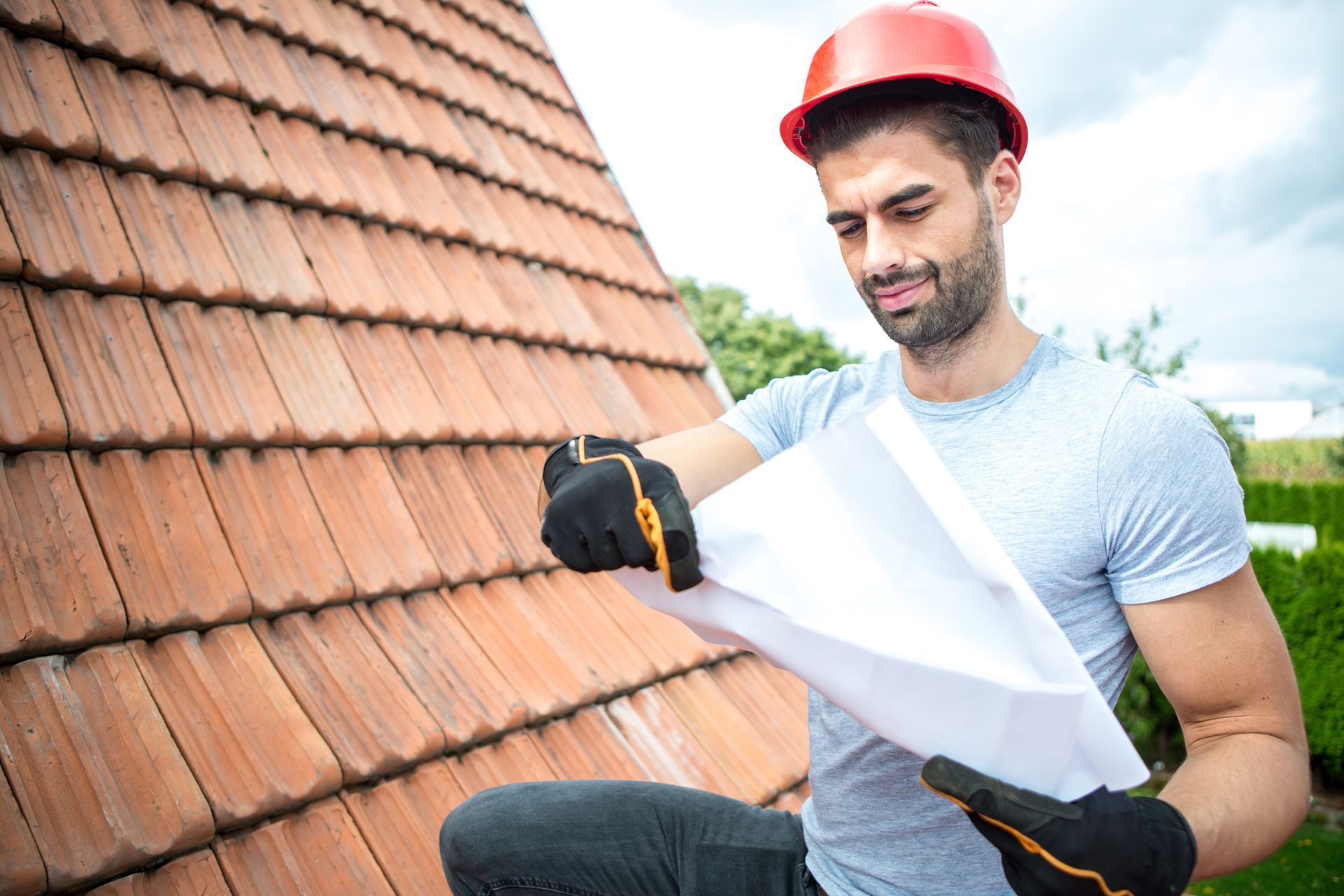 A roofer is looking at plans for replacing a roof.