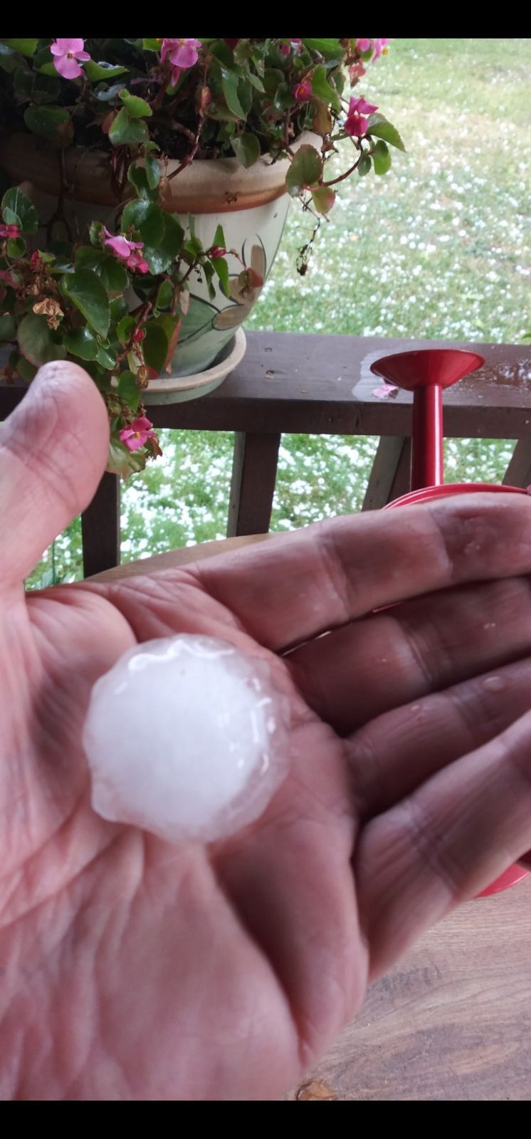 A person is holding a piece of hail in their hand.