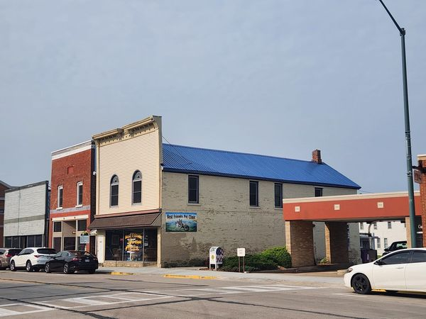 A white car is parked in front of a building with a blue roof — Holmen, WI — Riverland Exteriors Corporation