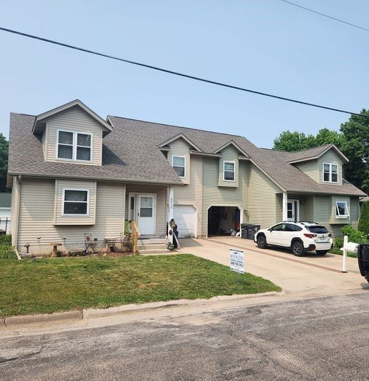 A white SUV is parked in front of a large house — Holmen, WI — Riverland Exteriors Corporation