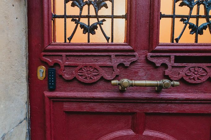 Un gros plan d'une porte rouge avec une poignée en laiton.