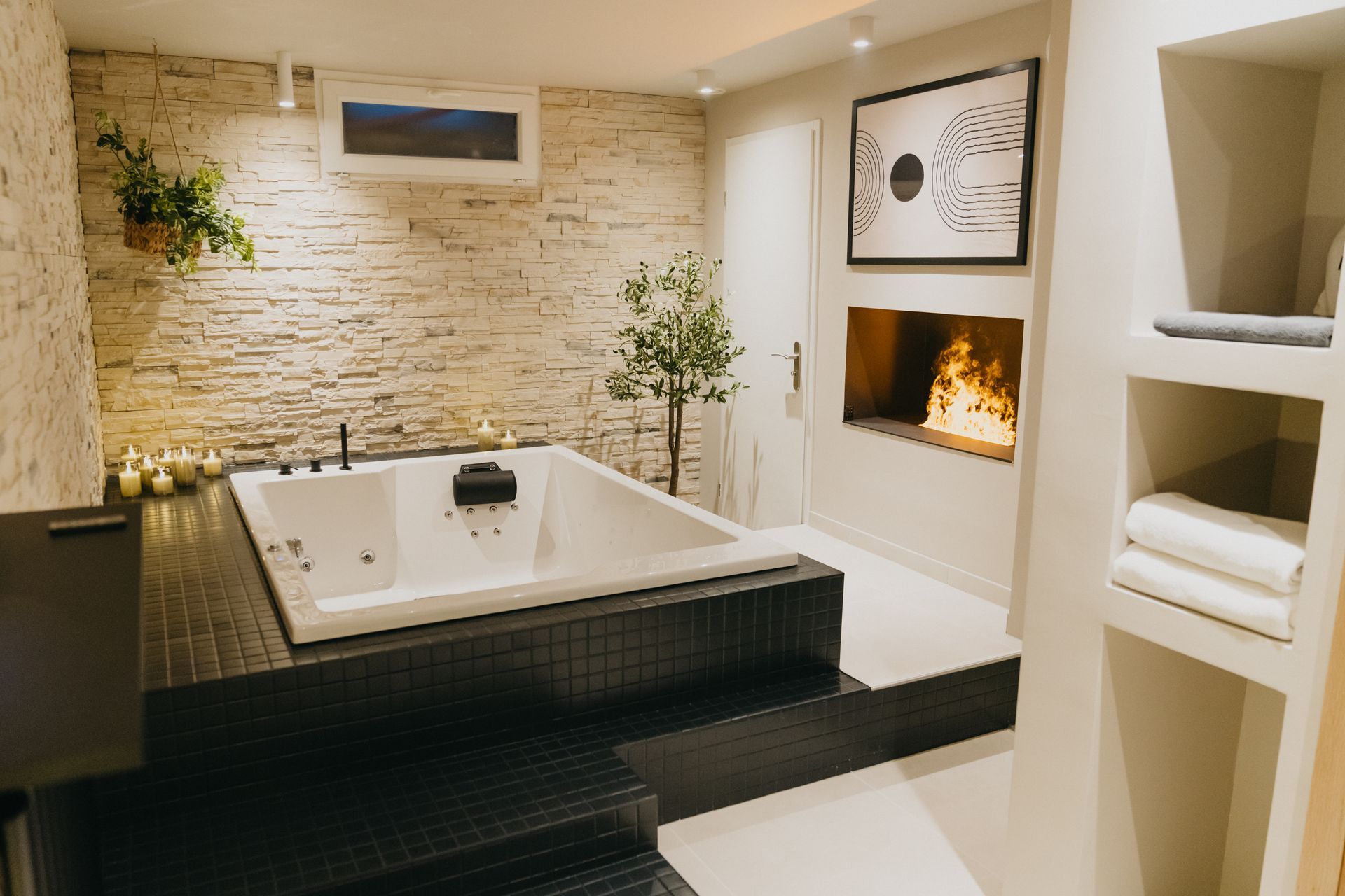Une salle de bain avec baignoire jacuzzi et cheminée.