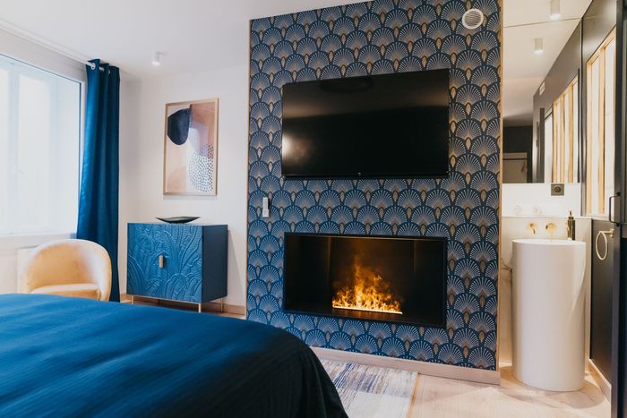 Une chambre avec cheminée, télévision et lavabo.