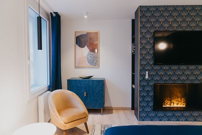 Un salon avec cheminée, fauteuil et télévision.