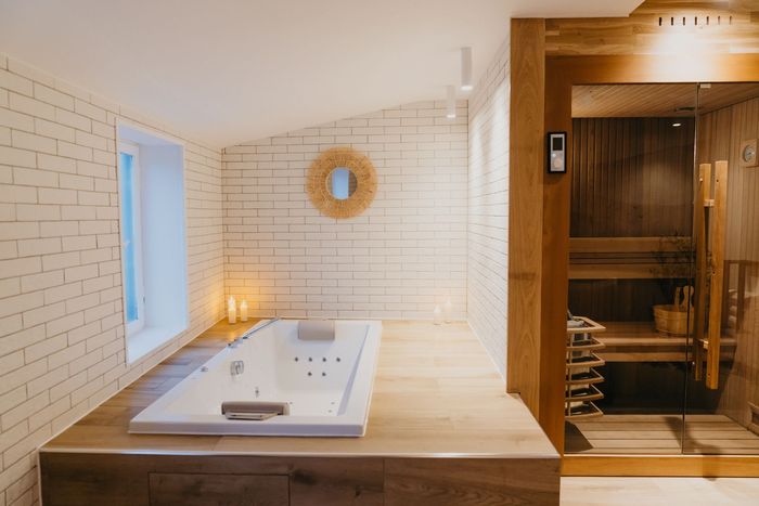 Une salle de bain avec baignoire jacuzzi et sauna.