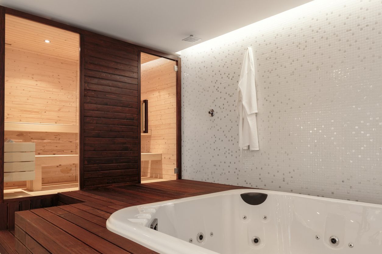 Il y a un jacuzzi au milieu de la pièce à côté d'un sauna.