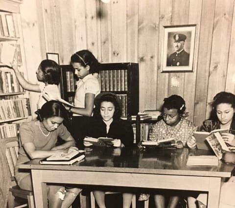 A black and white photo of a group of people reading books