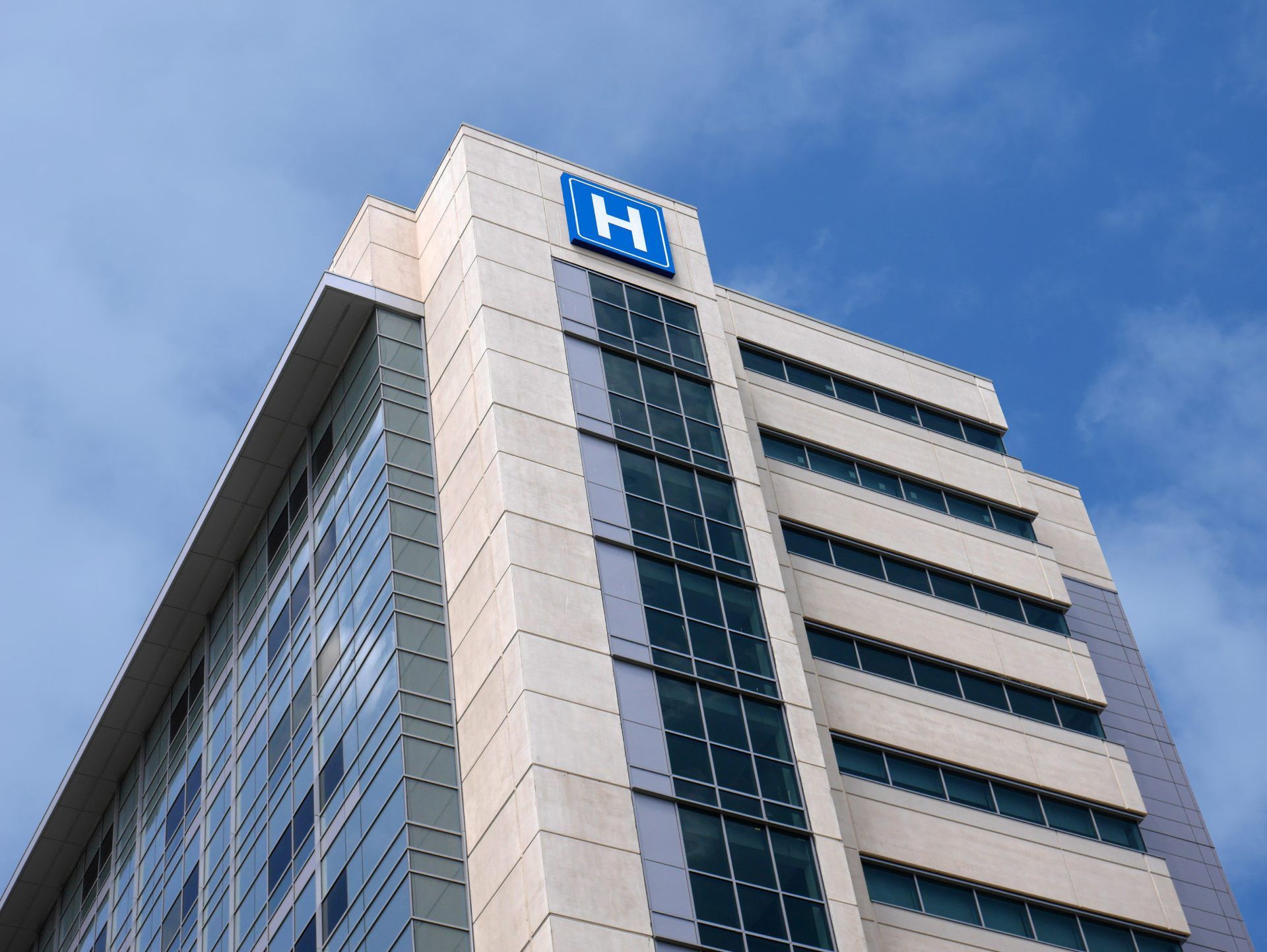 A tall modern hospital building with a blue
