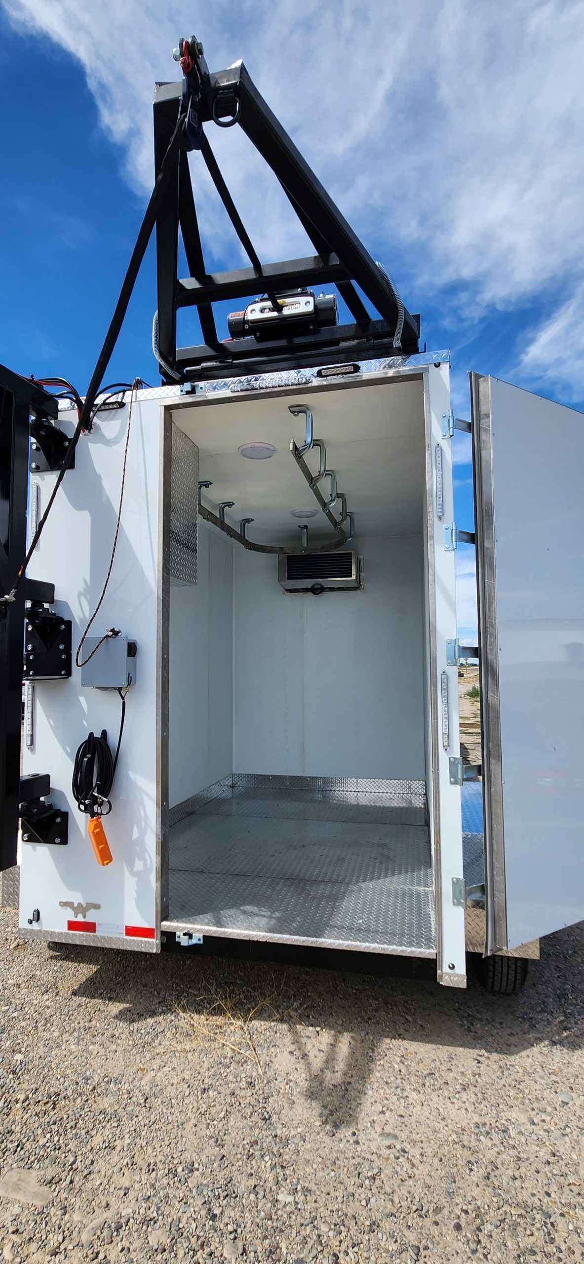 White utility truck with open rear cargo compartment and mounted black crane on top