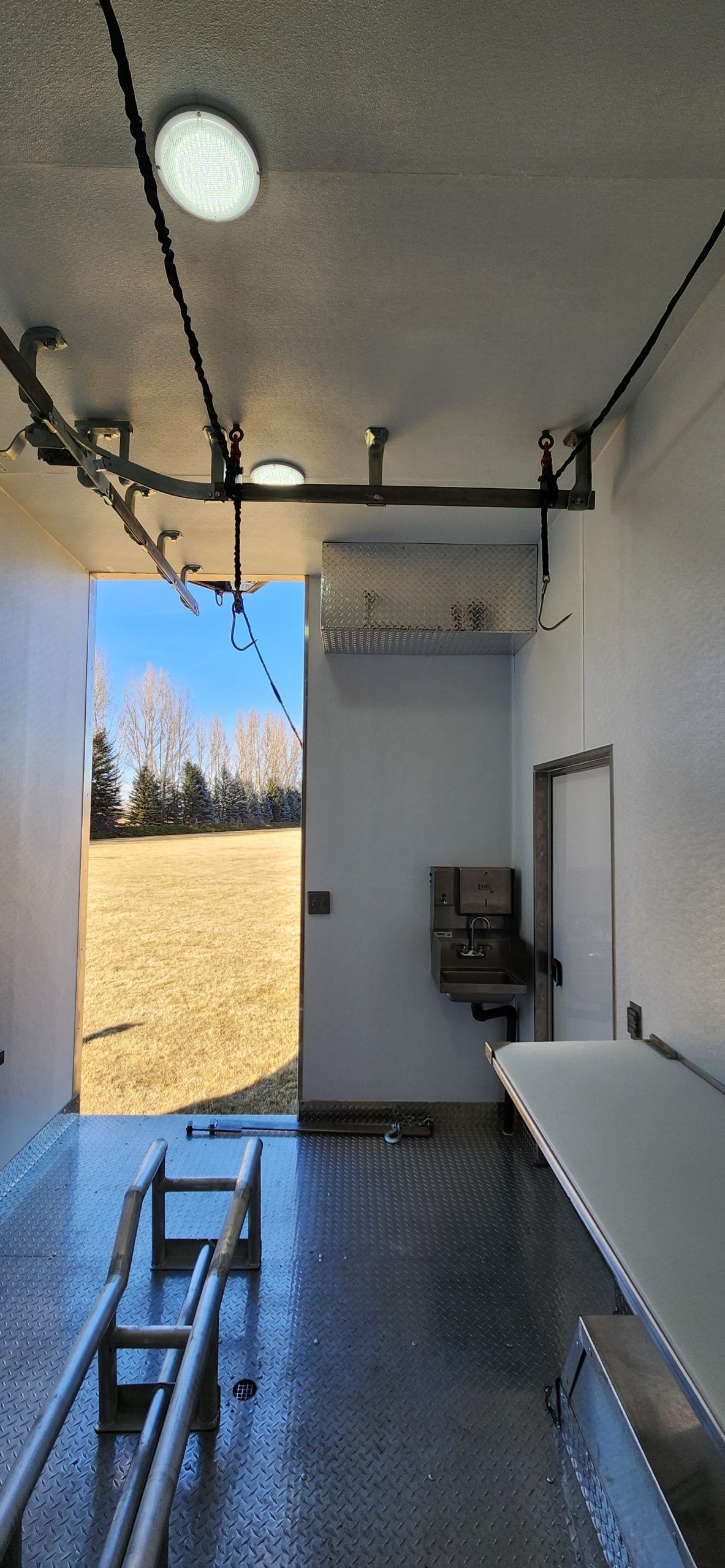 Inside a Sentinel trailer with lights and meat processing rails