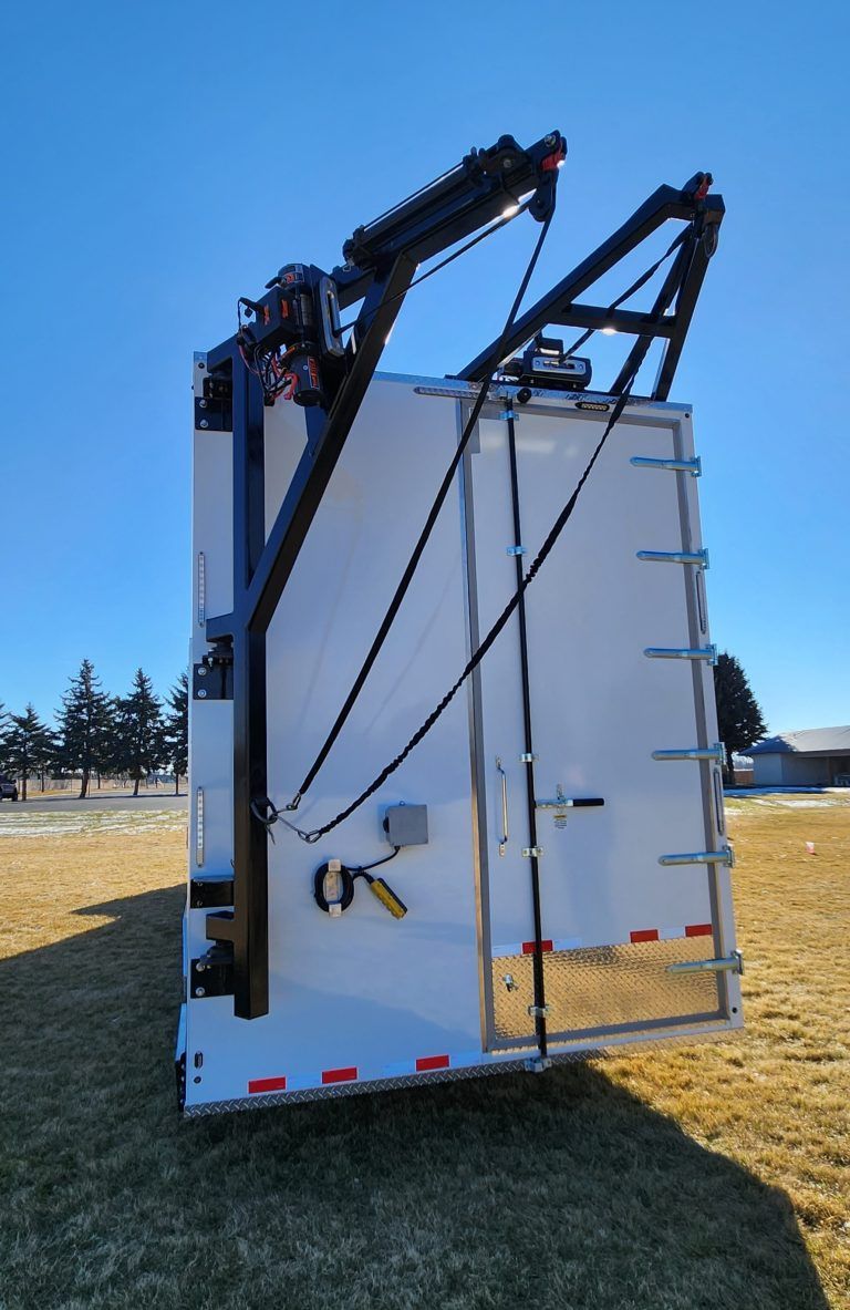 White truck rear with black mounted lifting arms for meat processing