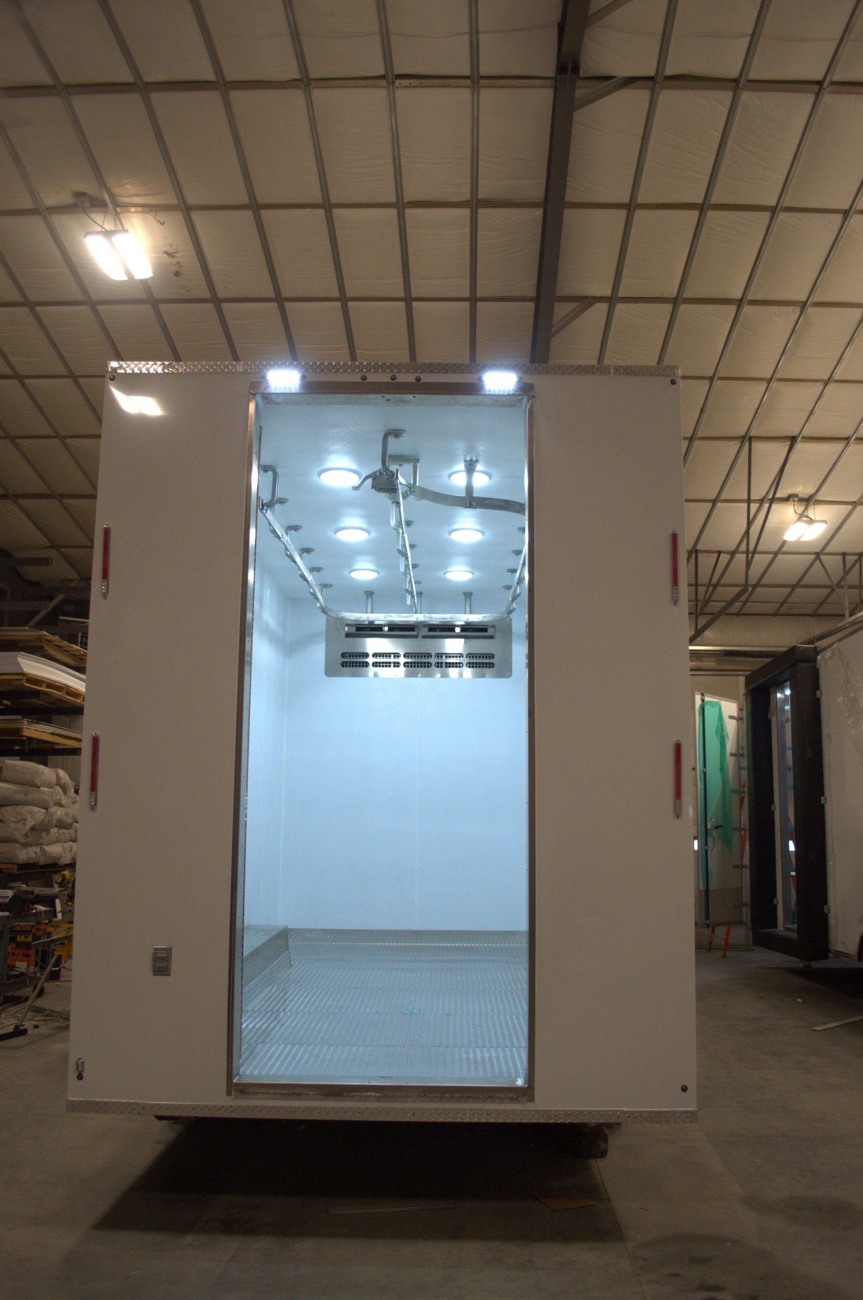 Mobile butcher trailer in the shop and bright interior lights in a warehouse.