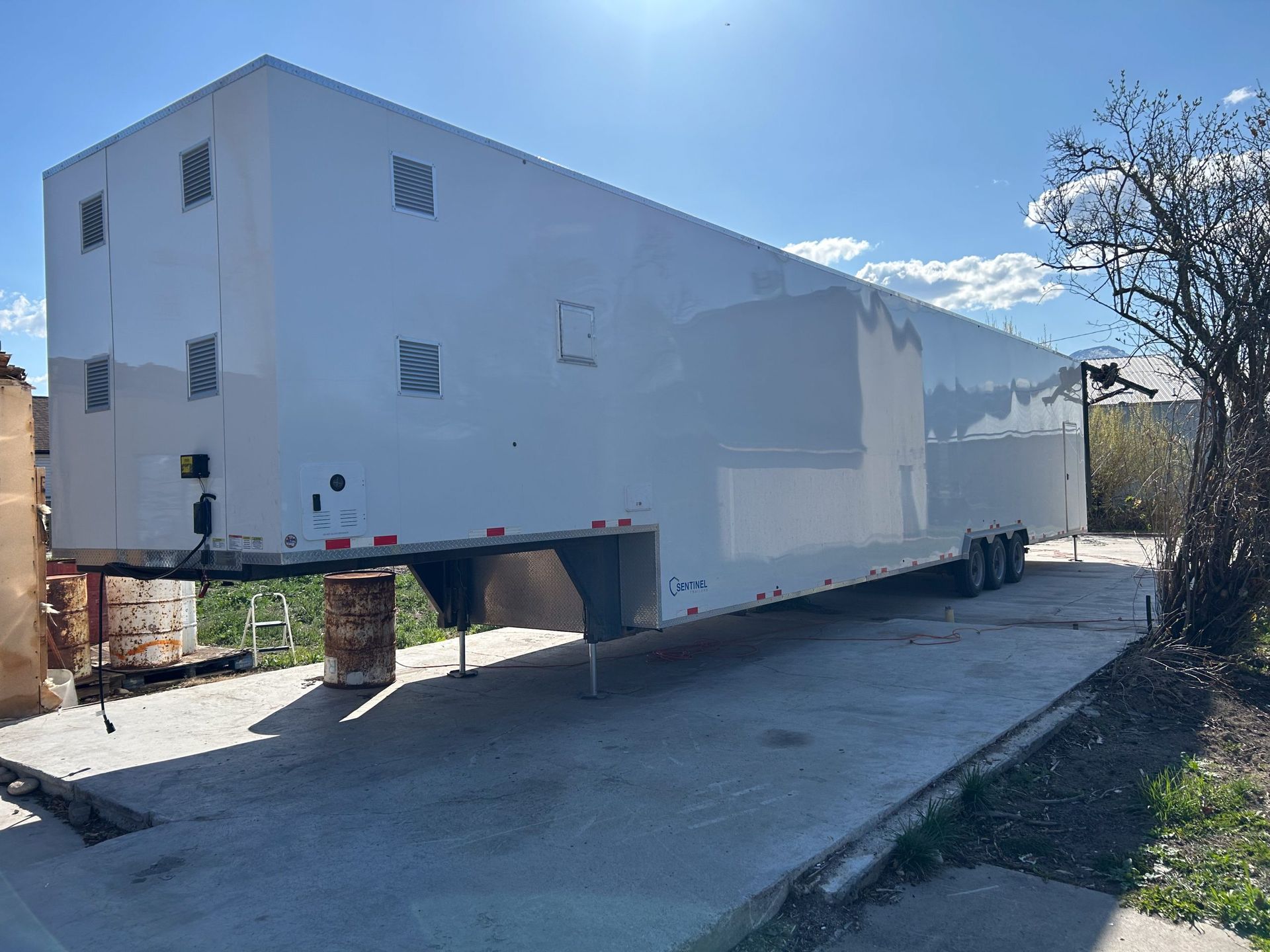 Meat processing semi trailer on supports over a concrete lot on a sunny day