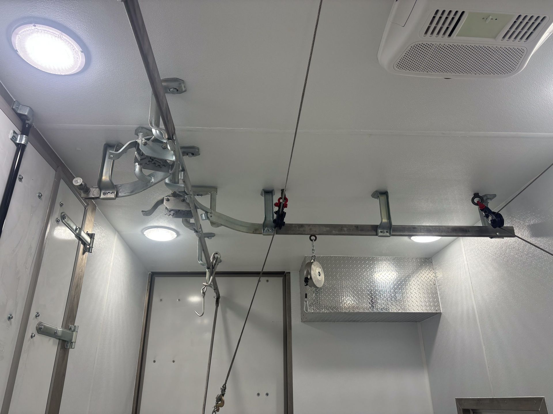 White butcher trailer ceiling with lights, rail for mobile meat processing