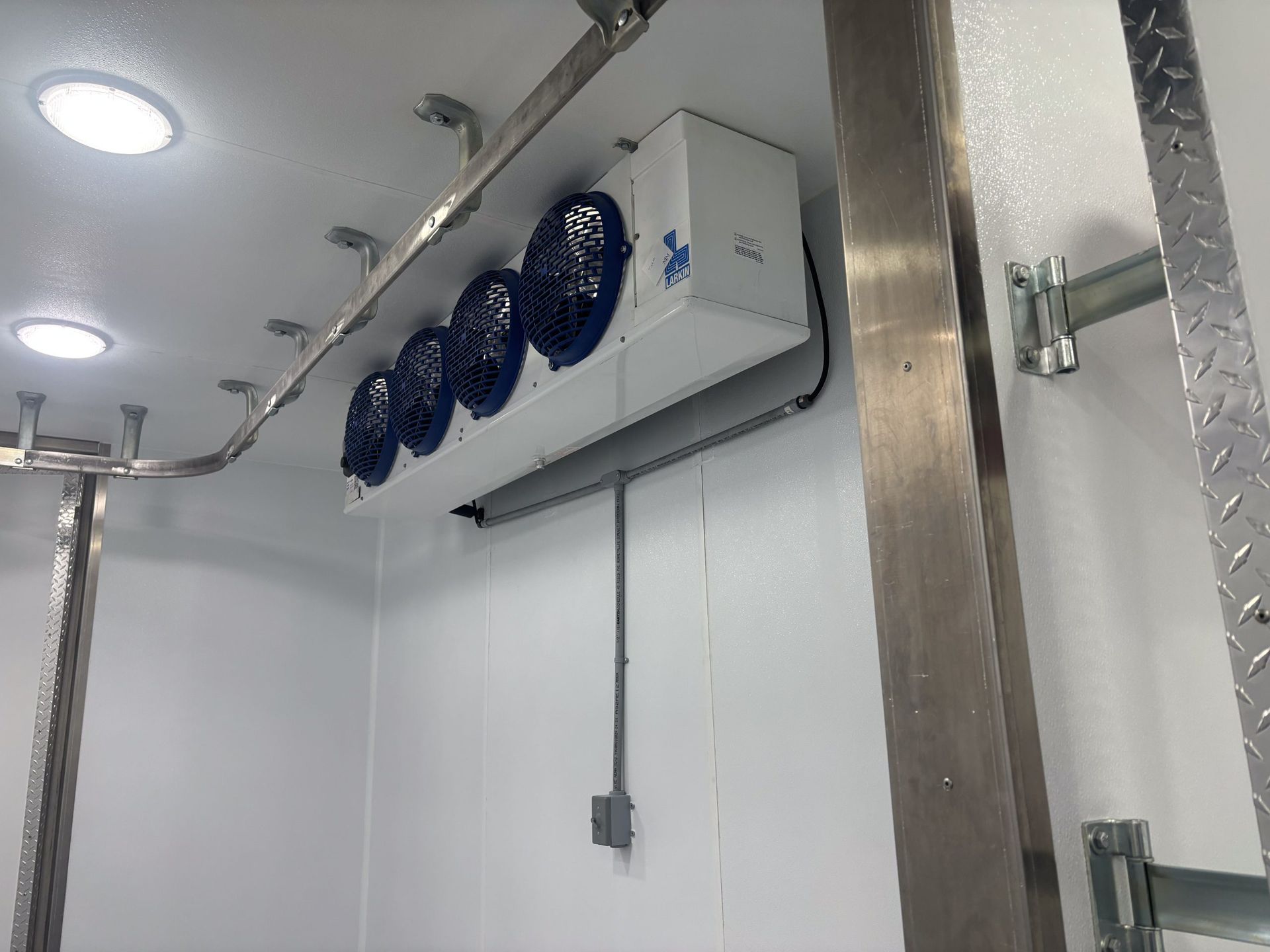 Walk-in cooler interior for Sentinel trailer, white walls, and stainless door frame.