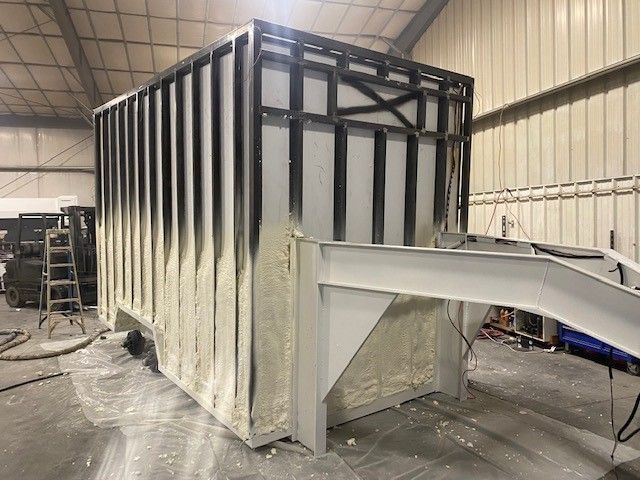Large industrial metal mobile slaughter trailer by Sentinel Trailers, with white and black framing on a concrete floor.
