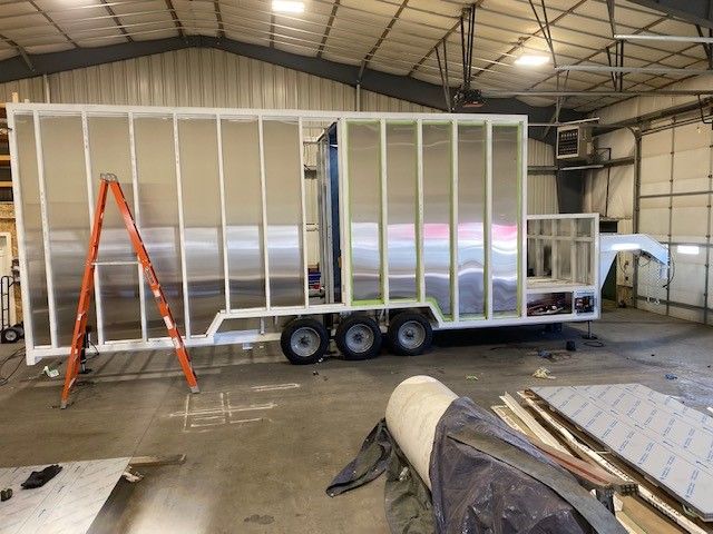 Sentinel Trailer frame under construction in a warehouse, with an orange ladder and exposed wall studs in Idaho Falls ID