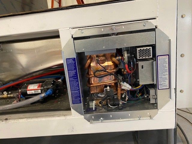 Open electrical cabinet with exposed wiring and copper components inside a white metal enclosure