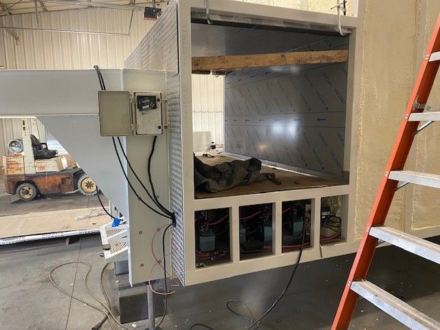 Gut compartment being built on a mobile slaughter trailer under construction beside a ladder in a workshop