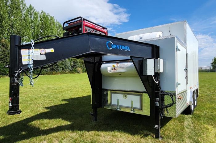 Butcher trailer in a grassy field.