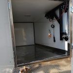 Wwhite walls, dark floor, and a ceiling-mounted exercise machine on the right.