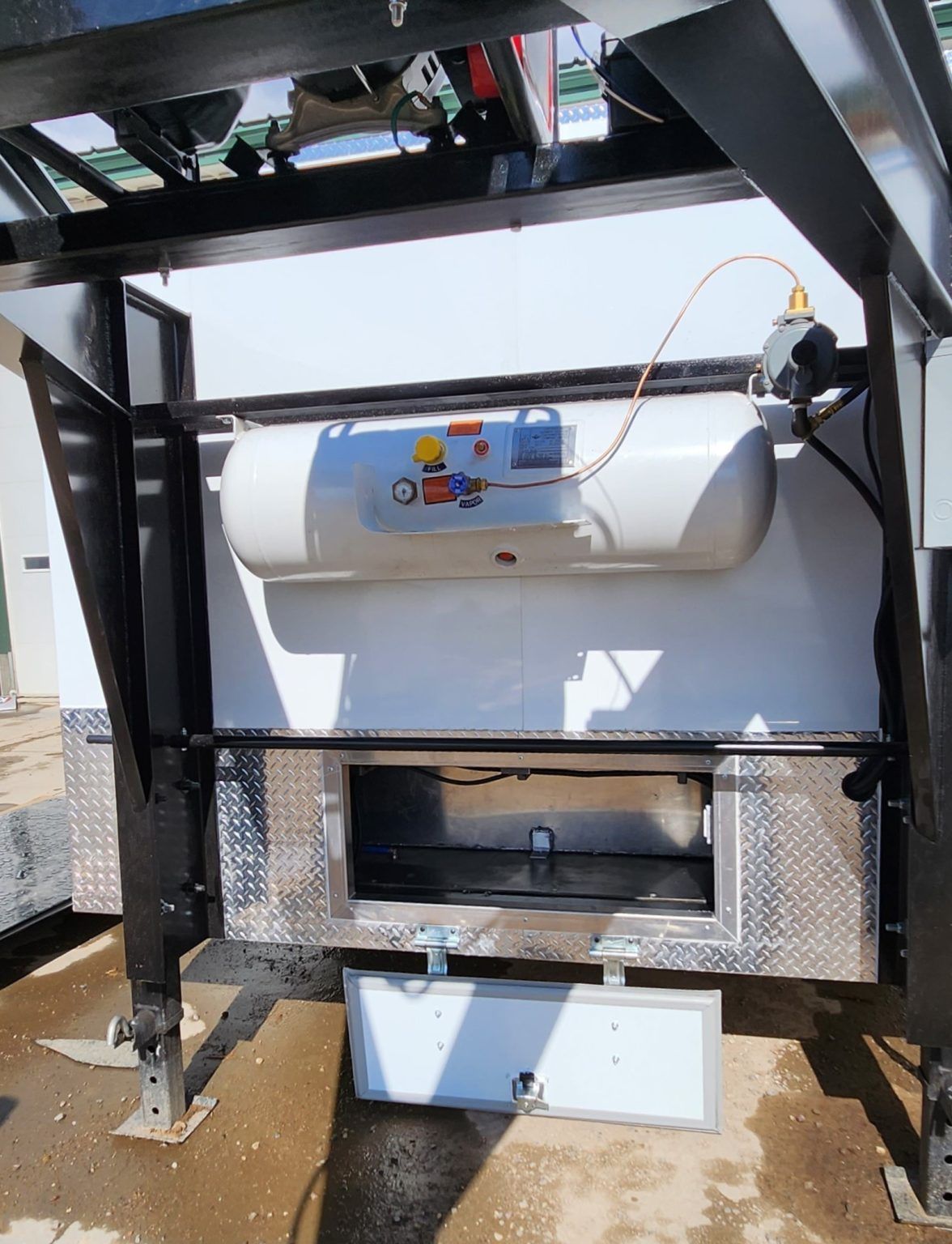 Industrial machine with a white cylindrical tank, blue control panel, and black steel frame.