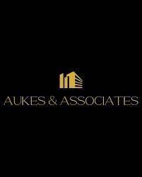 the logo for aukes & associates is on a black background .