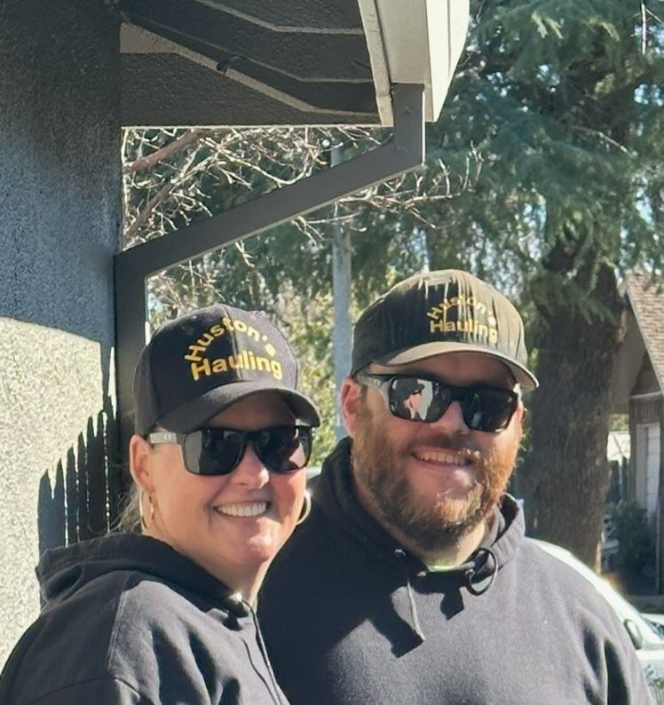 a man and a woman wearing sunglasses and hats that say Huston's Hauling