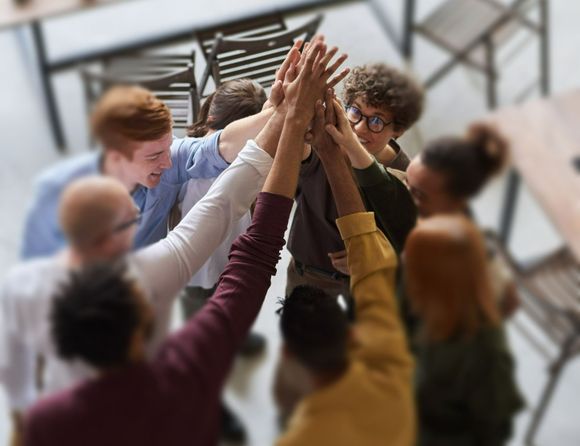 a group of people are giving each other a high five .