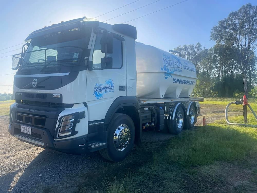 A White Truck Is Parked in A Grassy Field — Stolzenberg Water Carriers in Gympie, QLD