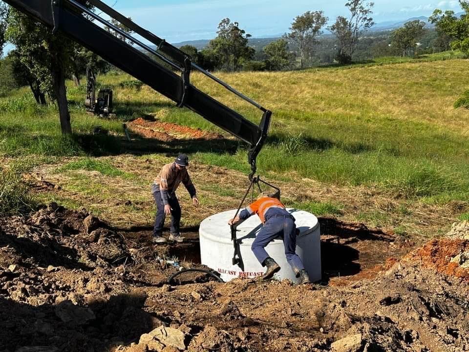 Two Men Are Working on A Large White Cylinder in The Dirt — Stolzenberg Water Carriers in Chatsworth, QLD