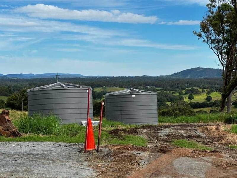 Two Water Tanks Are in A Field with Mountains in The Background — Stolzenberg Water Carriers in Chatsworth, QLD