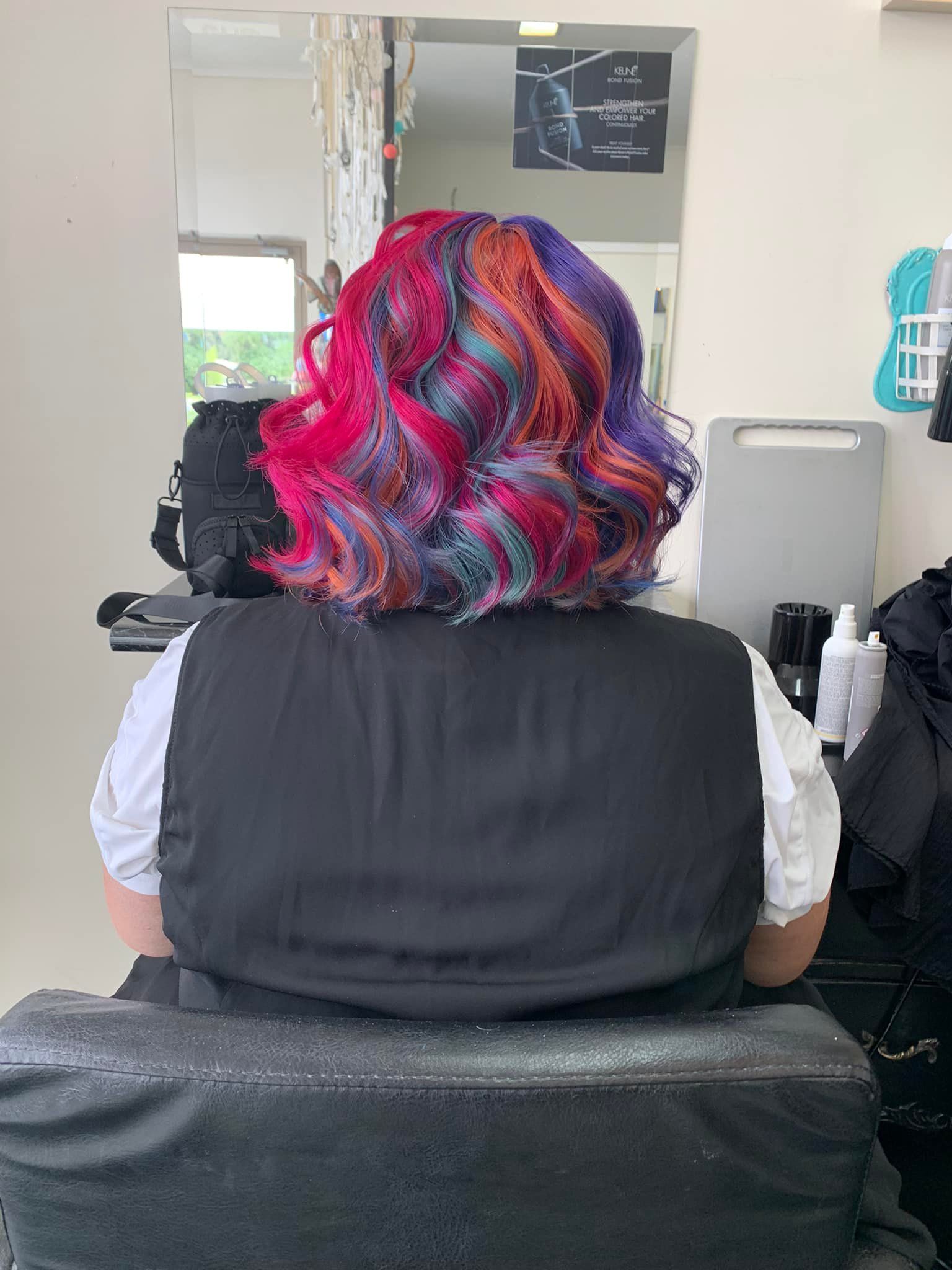 A Woman With Colourful Hair is Sitting in a Chair in a Salon — Southside Hair & Beauty Design In South Tamworth, NSW