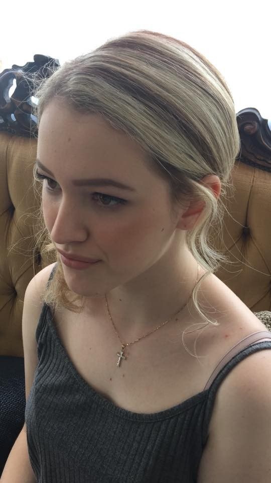 A Woman is Sitting on a Couch Wearing a Black Tank Top and a Necklace — Southside Hair & Beauty Design In South Tamworth, NSW