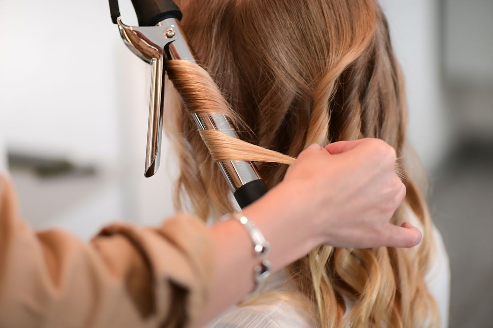 Hair Being Curled With a Curling Iron — Southside Hair & Beauty Design In South Tamworth, NSW