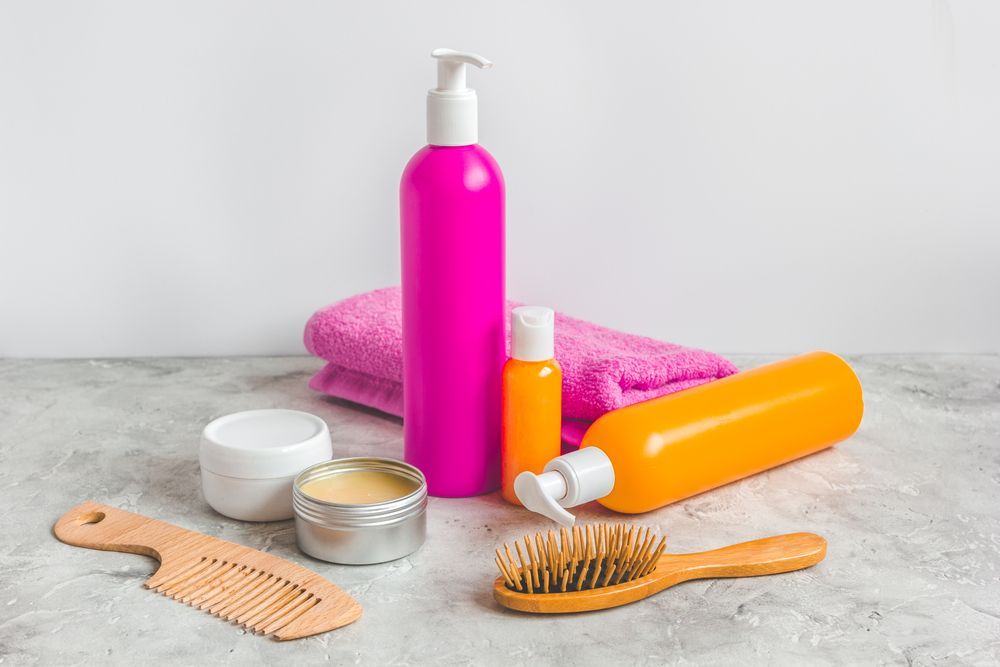 Hair Care Products: Pink and Orange Bottles, a Towel — Southside Hair & Beauty Design In South Tamworth, NSW