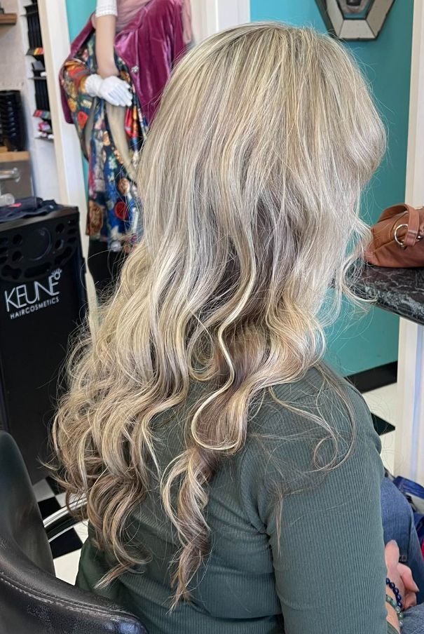 A Woman With Long Blonde Hair is Sitting in a Chair in a Salon — Southside Hair & Beauty Design In South Tamworth, NSW