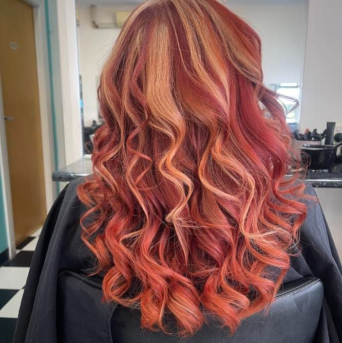 A Woman With Long Red Hair is Sitting in a Chair in a Salon — Southside Hair & Beauty Design In South Tamworth, NSW
