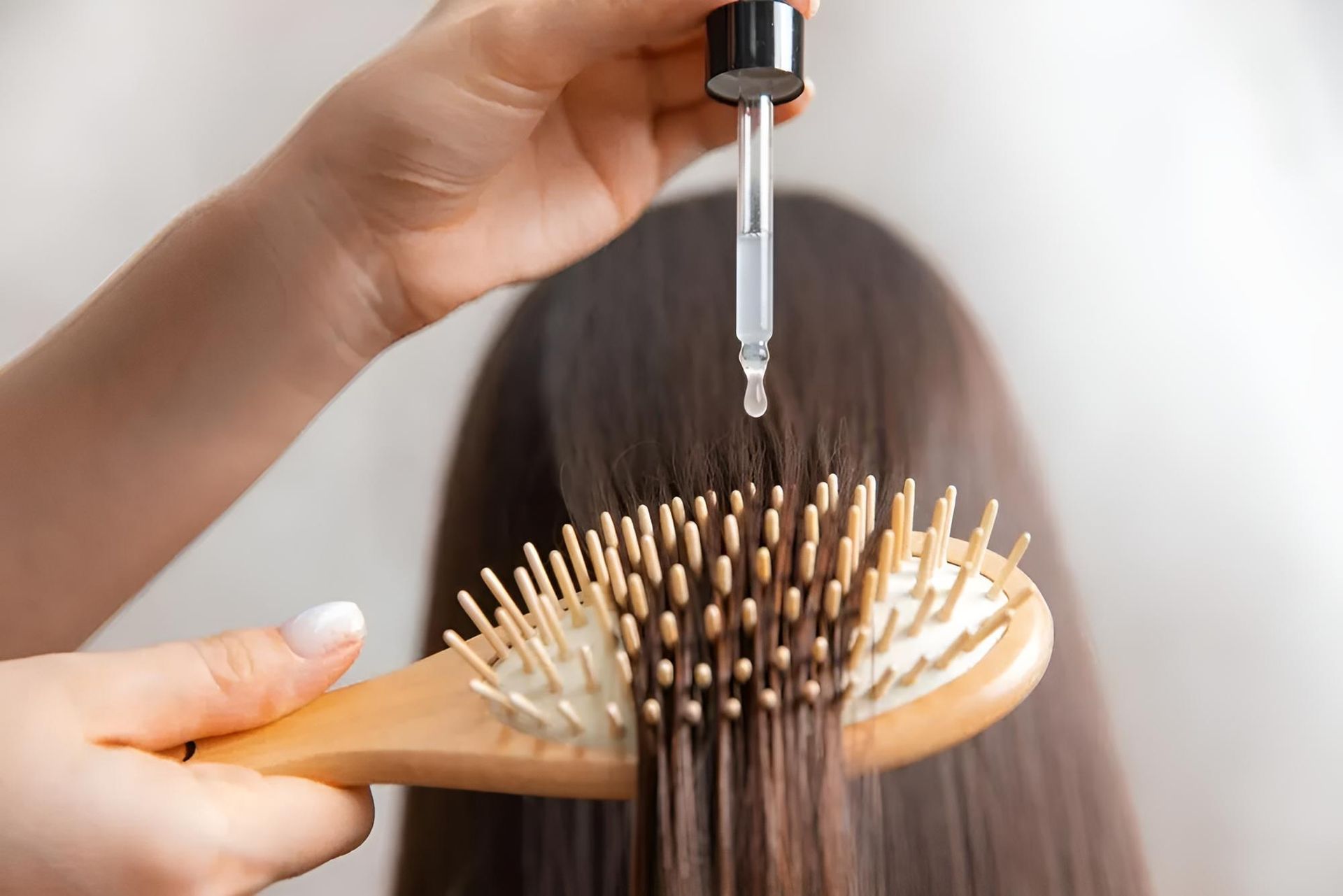 A Woman is Applying Oil to Her Hair — Southside Hair & Beauty Design In South Tamworth, NSW