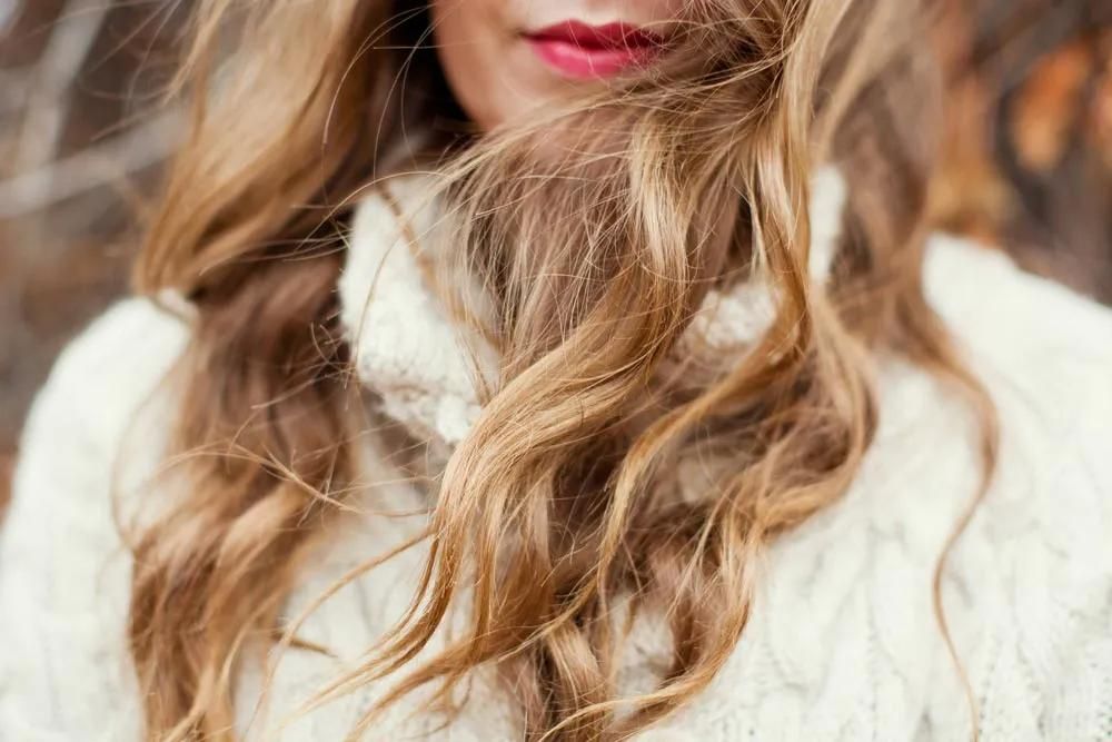 A Close Up of a Woman Wearing a White Sweater With Her Hair Blowing in the Wind — Southside Hair & Beauty Design In South Tamworth, NSW A Close Up of a Woman Wearing a White Sweater With Her Hair — Southside Hair & Beauty Design In South Tamworth, NSW